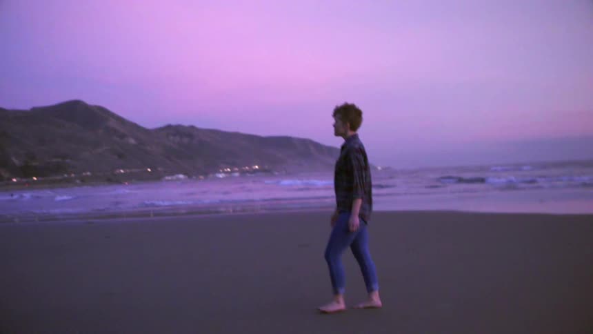 A woman is walking on the beach