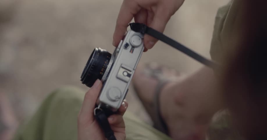 White woman handling a silver digital camera