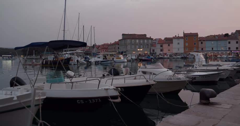 Boats moored in a marina on a cloudy evening