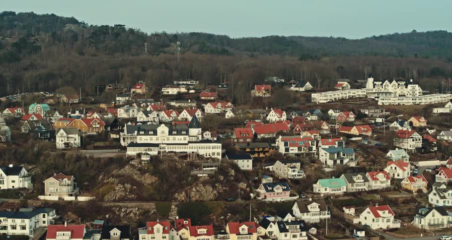 Houses in a small town sit near the tree covered hills