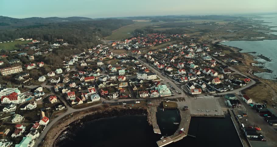 Aerial view of a city near a coast is displayed