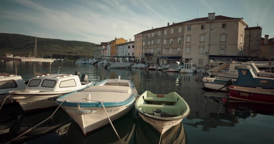 Boats floating in a harbor with buildings in the distance
