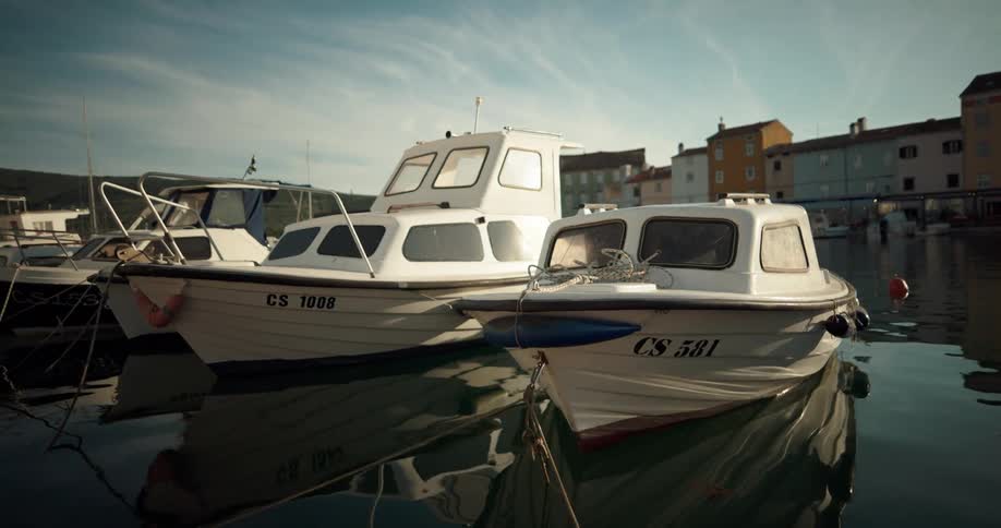 A line of boats moored in a marina during the day