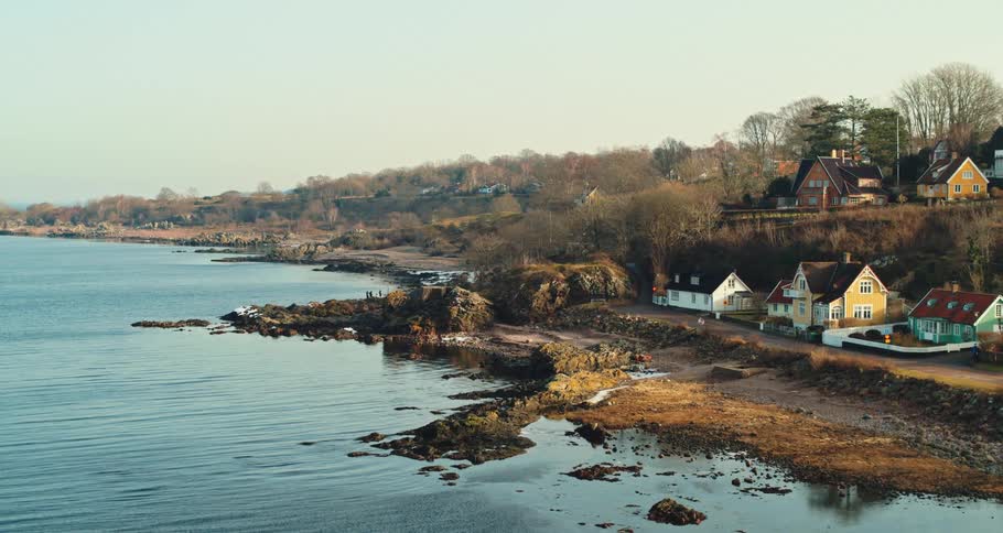 Aerial view of the bay in front of a a calm small coastal town close to the ocean at morning
