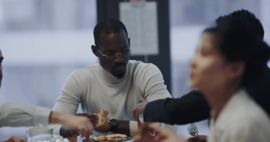 A group of people eat together indoors during the day