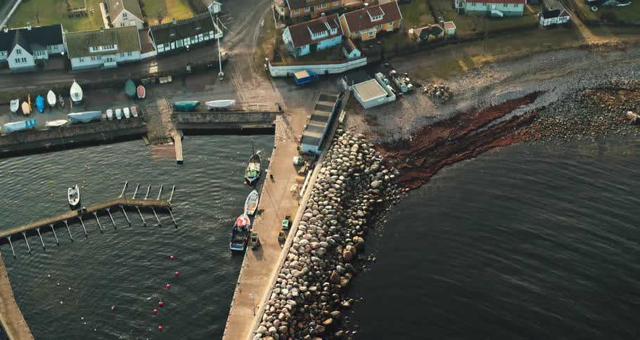 Aerial view of the bay in front of a a calm small coastal town close to the ocean at morning