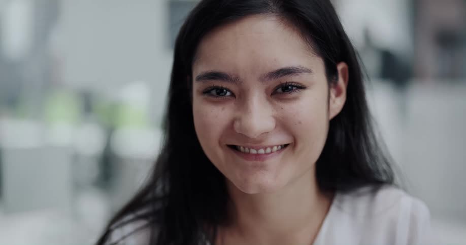 A woman smiles while posing for a close up