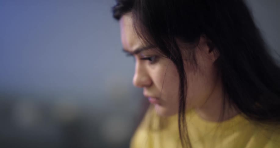 Young woman looking very worried after finishing a call on her phone and starting to look for something in some papers