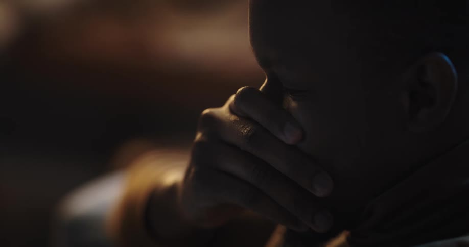 Man sits shaking his head and covering his mouth and eyes with his hands in turn