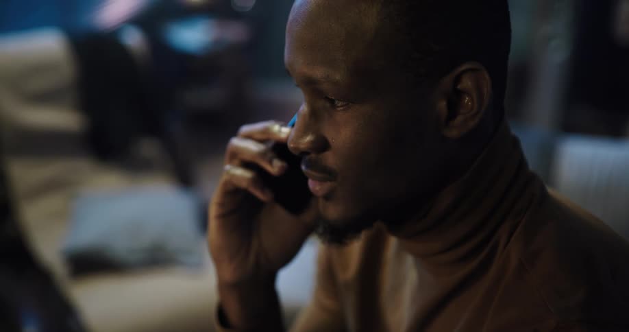 A black man is talking on his phone