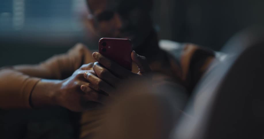 Man sitting on the couch with his legs up using his smartphone