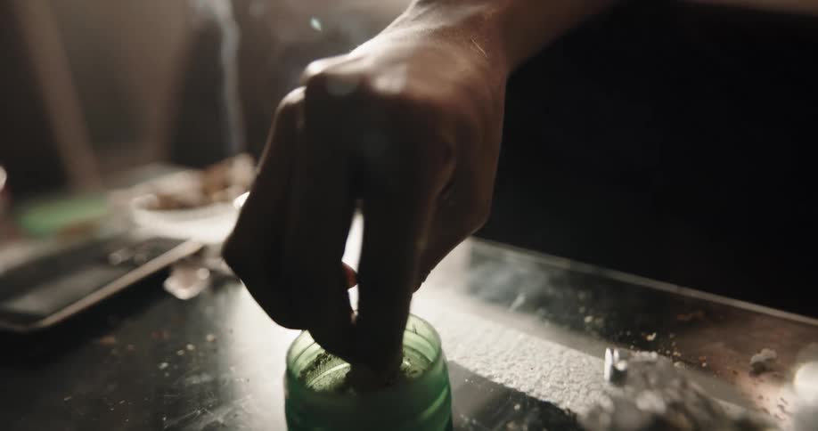 A person rolling up weed in a room