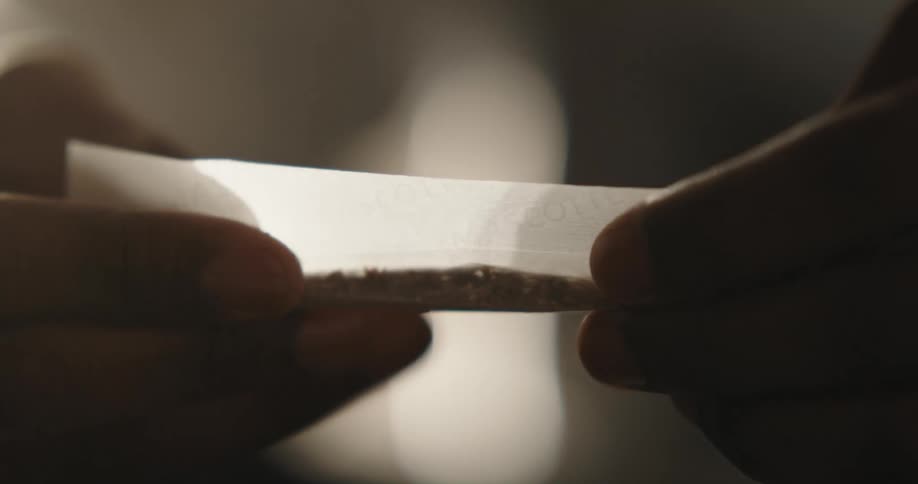 Hand of a black man rolling a joint