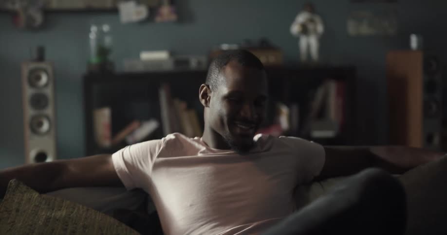 Man sits in living room bobbing his head while listening to music