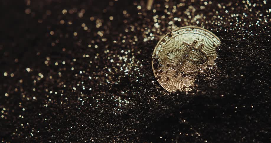 A gold coin in a pile of dirt