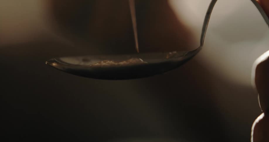 Liquid is added with a syringe to a substance in a spoon and the contents of the spoon bubble up