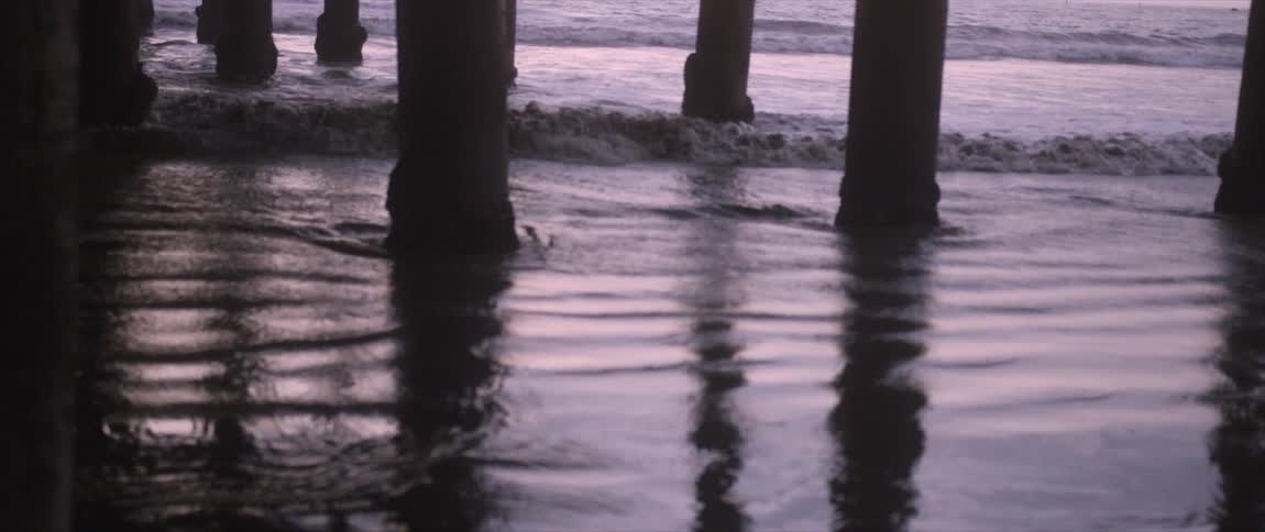 Waves rolling in to the shore at a pier
