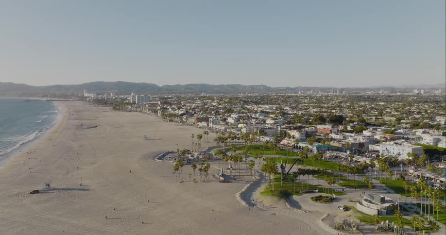 Aerial view of a group of people skateboarding on a skate park on the beach at evening