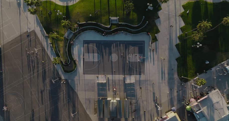 Aerial view of a group of people using the sports courts on a park near the beach at morning