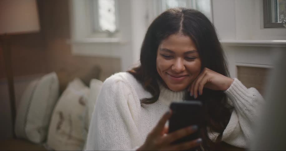 A woman laughs while using his cell phone