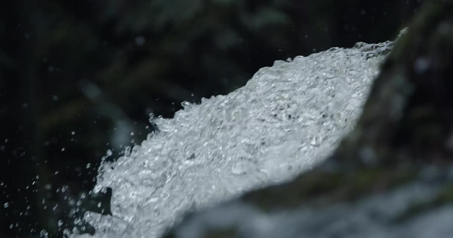 Water is splashing and sparkling in the light as it falls over the edge