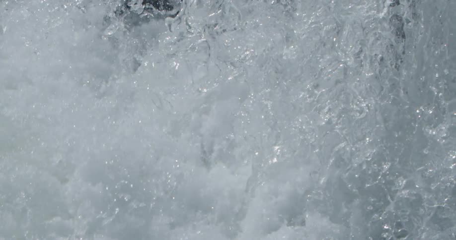 Slow motion water forms patterns as it crashes over a waterfall