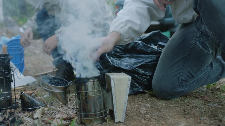 Campers encourage smoke while building a fire