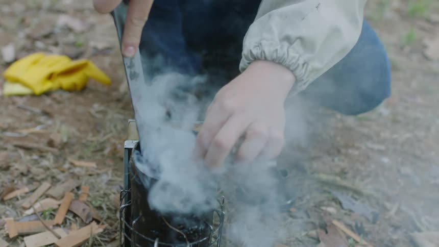 A beekeeper gets his smoke tool ready