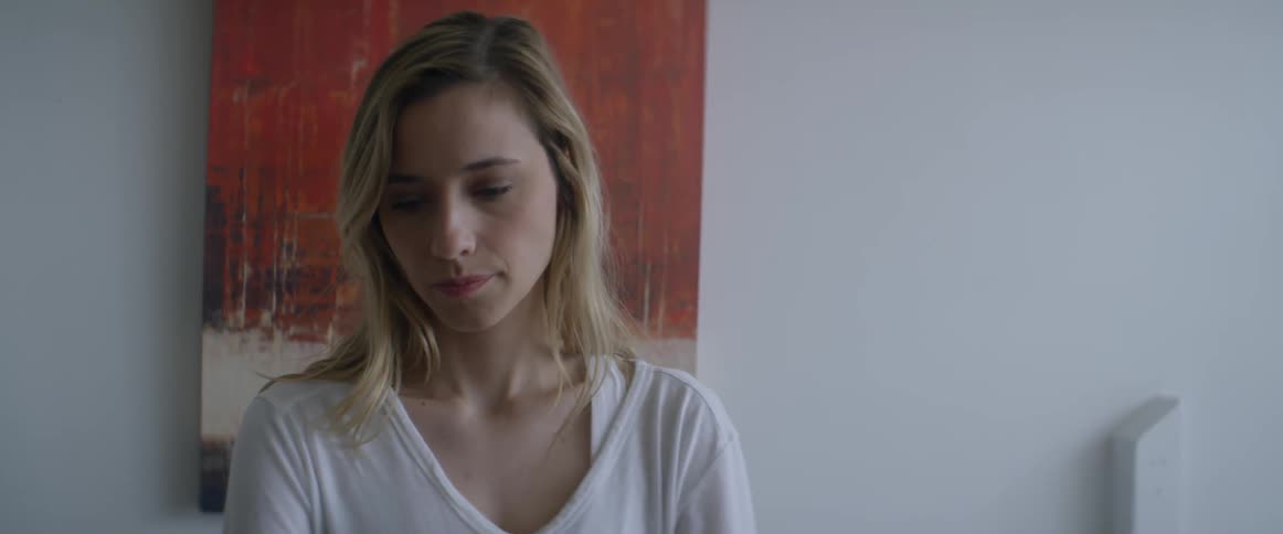 A woman is in front of a painting looking down