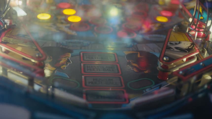 Close up of the blinking colorful lights on the surface of a pinball machine
