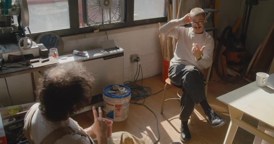 Two men talk together in the room