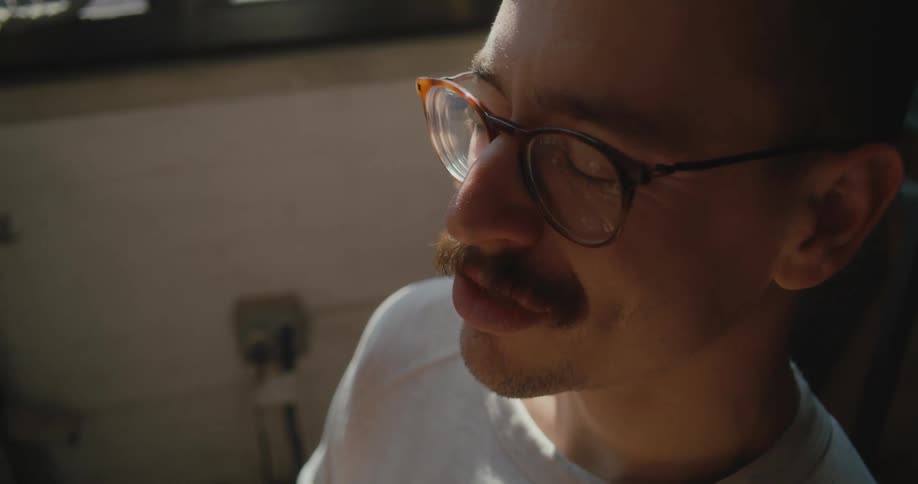 Man sitting near window uses sign language as he talks