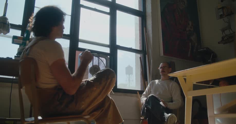 Two men sitting face to face talk to each other in room
