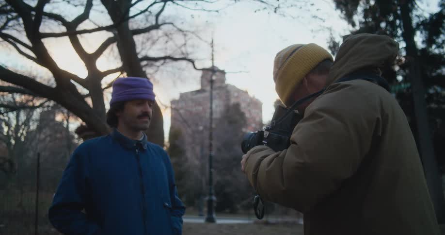 A man is posing for photographs in the park