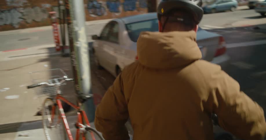 A man gets off his bike and locks it up