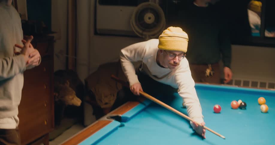 A man is playing pool at night