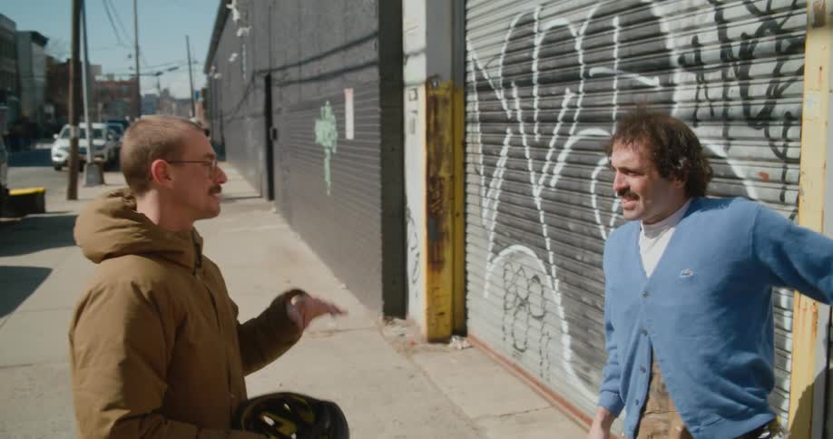 Two men walk down the sidewalk talking with sign language