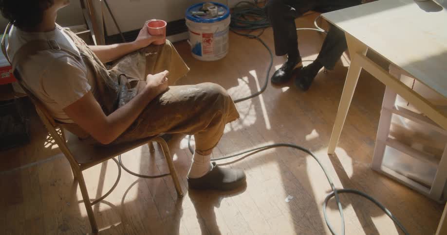 Two men sit inside and talk