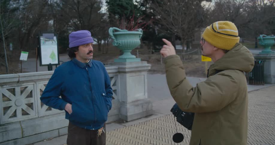 A pair of men communicate through sign language while standing outdoors during the day
