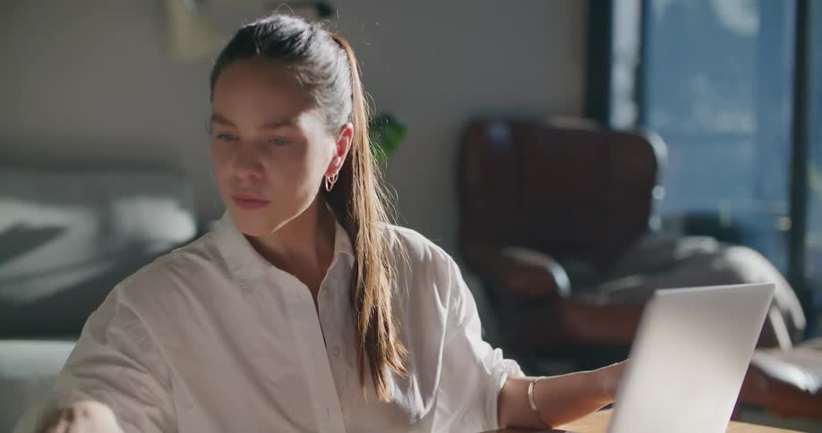 Woman sitting in the livingroom at home working on a laptop