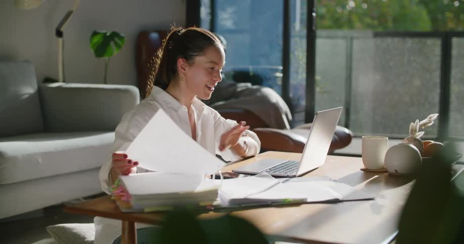 A woman is talking on her laptop as she works from home