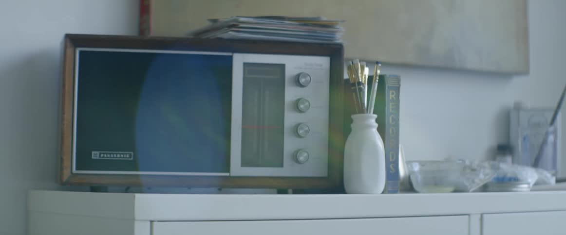 A radio sits on a dresser