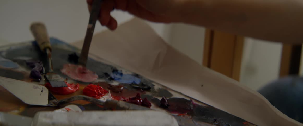 A person is mixing paint with a brush