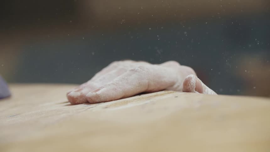 A person with powder on their hand grabs the surface