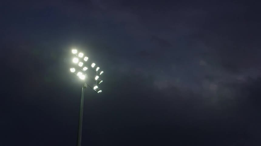 A stadium light post against the night sky
