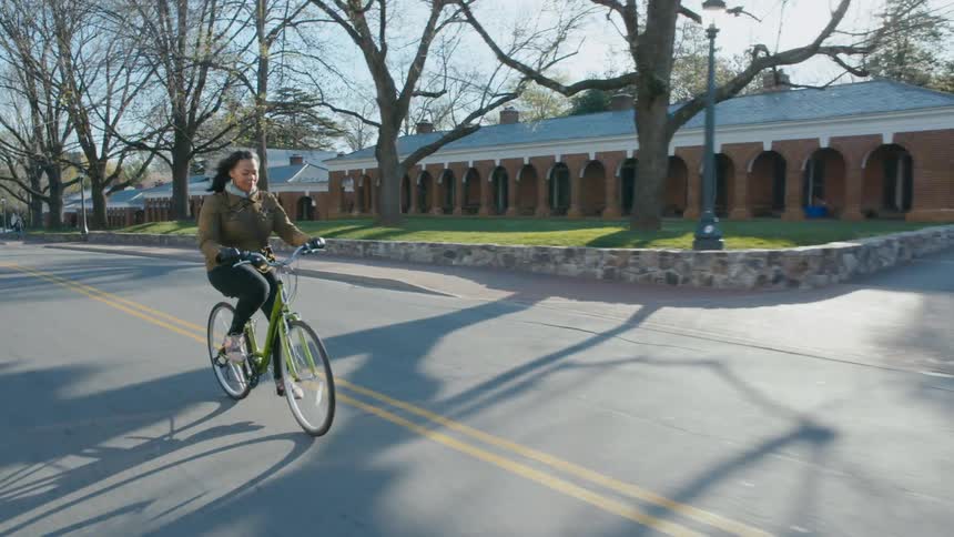 Woman rides a bicycle down the middle of a road