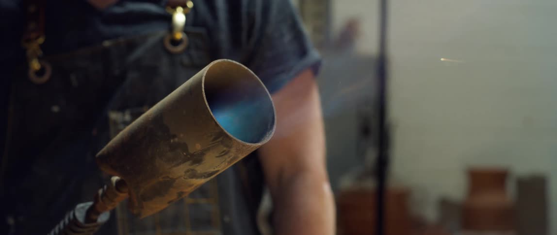 A man lights a torch and the flame turns blue