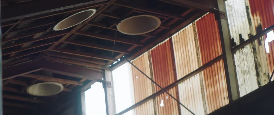 A wood beamed ceiling with large round tubes in an old barn