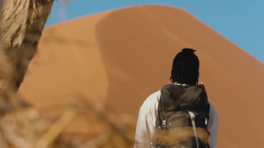 Woman walking up to a sand dune in the desert