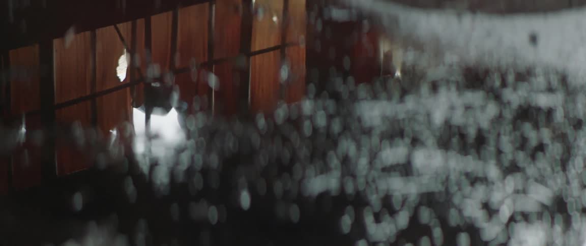 Puddle reflects torn fabric and window